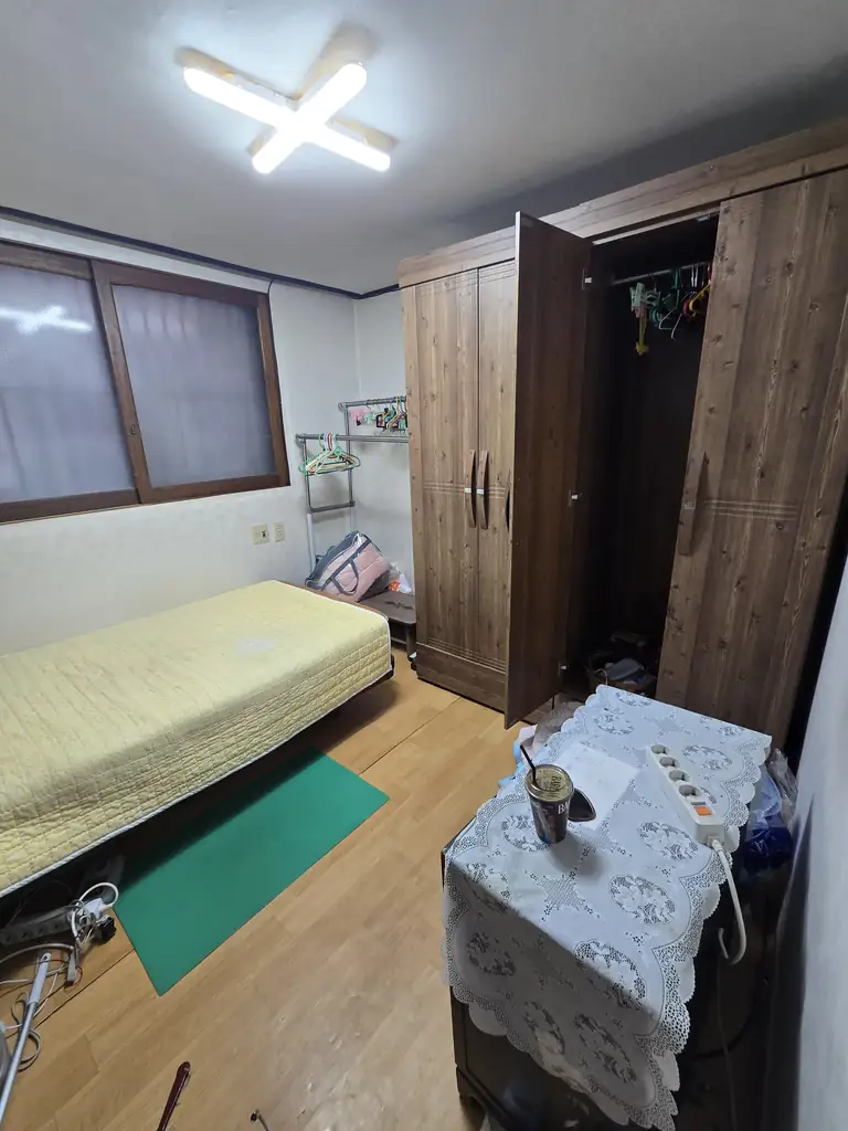 침대와 장롱, 생활 물품이 남아 있는 방 정리 전
