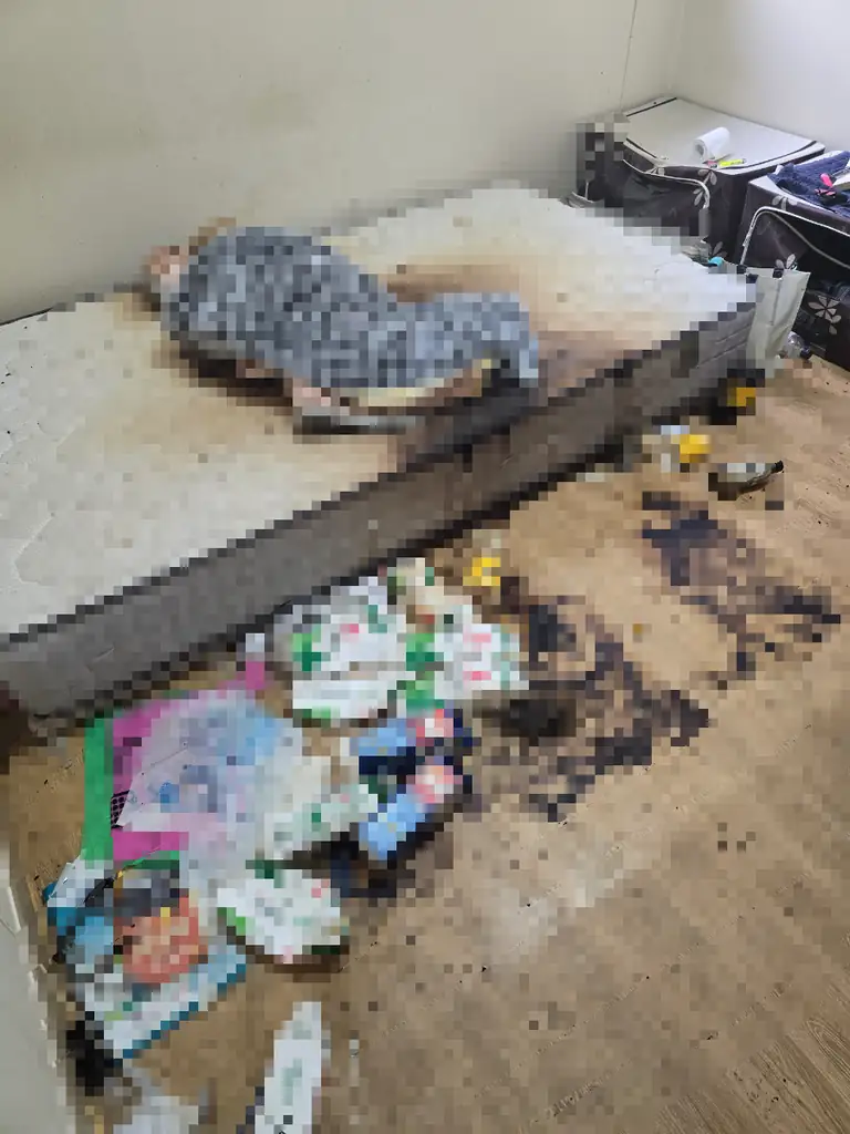 고독사청소 전 침대 주변 오염과 생활물품이 남아 있는 공간