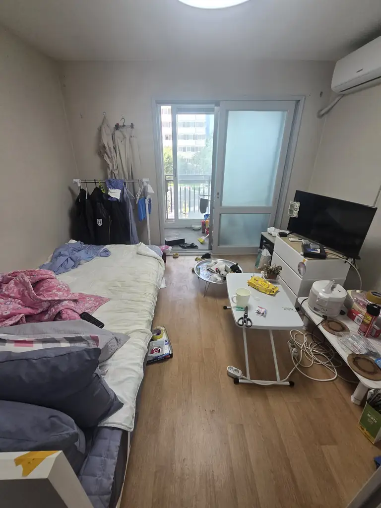 유품정리 작업 전 침대와 의류, 생활용품이 놓인 방